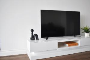 a white tv stand with a flat screen tv at Modern two bedroom in Brentwood London in Brentwood