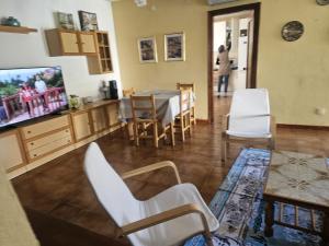 sala de estar con TV, mesa y sillas en CASA CUNIT, en Cunit