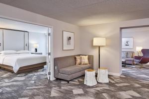 ein Schlafzimmer mit einem Bett, einem Sofa und einem Stuhl in der Unterkunft Sheraton Portland Airport Hotel in Portland