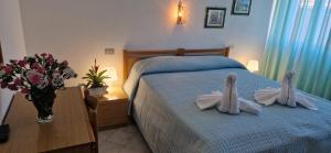 ein Schlafzimmer mit einem Bett mit zwei weißen Hasenohren in der Unterkunft Hotel Dora in Levanto