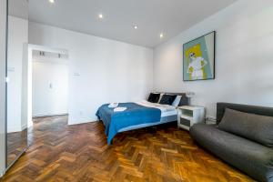 a bedroom with a bed and a couch at Warsaw Concierge Grójecka View in Warsaw