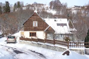 a house with a fence in the snow at Villa Nina in Besse-et-Saint-Anastaise