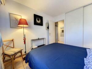 um quarto com uma cama azul e uma cadeira em Le Stadium - 2 pers - Proche Centre - Mouans-Sartoux em Mouans-Sartoux