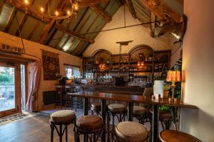 a bar with wooden tables and stools in a room at The George Inn & Plaine in Norton Saint Philip