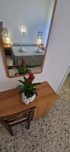 einen Spiegel auf einem Tisch mit einem Bett in einem Zimmer in der Unterkunft Hotel Dora in Levanto