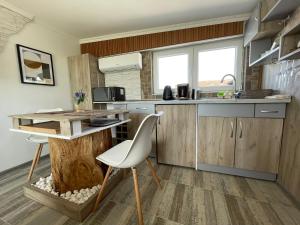 a kitchen with a table and chairs and a counter at Diamona Lux Spa Apartman in Niš