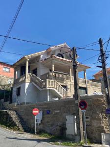 ein großes weißes Haus mit Treppen auf einem Gebäude in der Unterkunft Casa Nerga, Cangas do Morrazo, O Hio in Hio