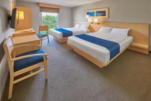 a hotel room with two beds and a tv at City Express by Marriott Aguascalientes Sur in Aguascalientes
