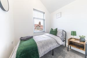 ein Schlafzimmer mit einem grünen Bett und einem Fenster in der Unterkunft 24 Baden Powell in Barrow in Furness