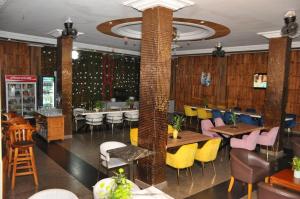 Freedom Palace Hôtel في بورتو-نوفو: مطعم مع كراسي ملونة وطاولات في غرفة