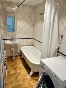 a bathroom with a bath tub and a sink at Skeppsdockans Vandrarhem in Söderköping