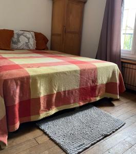 - une chambre avec un lit doté d'une couverture et d'un tapis dans l'établissement KECYHOUSE, à Sevran