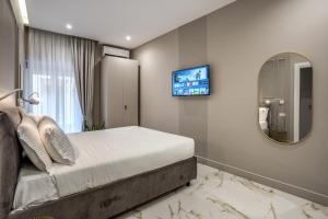 - une chambre avec un lit, un miroir et une télévision dans l'établissement The Oasis, à Naples