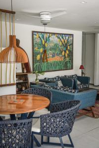 a dining room with a table and chairs and a painting at Pousada Bahia Inn in Morro de São Paulo