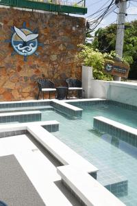 uma piscina com cadeiras e uma placa na parede em Pousada Bahia Inn em Morro de São Paulo