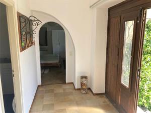 - un couloir avec une porte en bois et un miroir dans l'établissement Bellaterra B, à Locarno