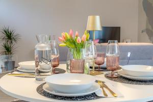 a table with plates and glasses and flowers on it at At Home-Como Lake in Como