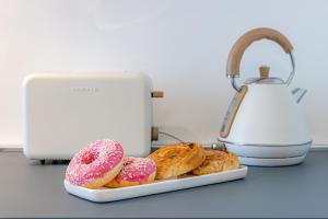 einen Teller Donuts auf einer Theke neben einem Toaster in der Unterkunft At Home-Como Lake in Como