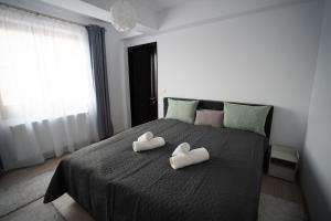 a bed with two hearts shaped towels on it at Alex 1 Apartament in Iaşi