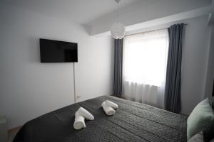a bedroom with a bed with two towels on it at Alex 1 Apartament in Iaşi