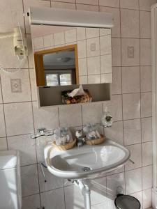 uma casa de banho com um lavatório e um espelho em Hotel Restaurant Edelweiss em Mühlen