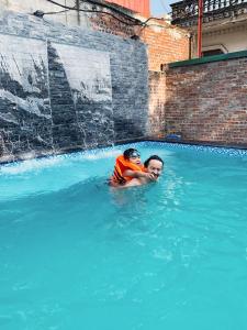 Dos personas están nadando en una piscina en Tam Coc Golden Sky Homestay, en Ninh Binh