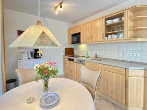 una cocina con una mesa con un jarrón de flores. en Residenz Bleichröder - Ferienwohnung 25, en Heringsdorf