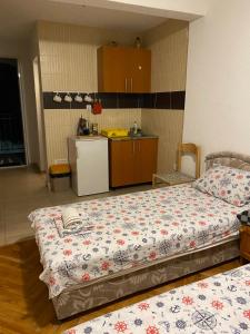 een kamer met 2 bedden en een kleine keuken bij Apartmani Rakocevic in Sutomore