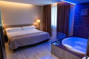 una camera d'albergo con letto e vasca di HOTEL GRAN VIA a Calera y Chozas