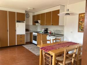 uma cozinha com armários de madeira e uma mesa com cadeiras em Bellaterra B em Locarno