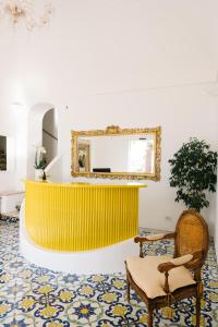 a living room with a yellow wall and a mirror at Villa Principe Giovanni in Positano