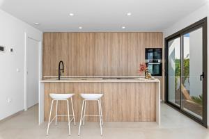 a kitchen with a counter and two stools at Luxury Villa Pilar De La Horadada in Pilar de la Horadada