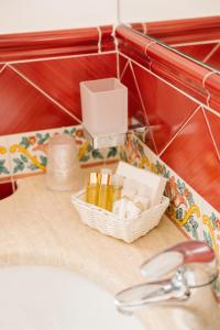a bathroom sink with a basket of soap and a faucet at Villa Principe Giovanni in Positano