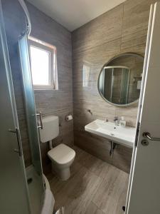 y baño con aseo, lavabo y espejo. en Apartments Puntamika, en Zadar