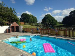 a swimming pool with two children playing in it at Morvoren Cottage in Launceston