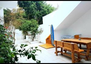 a patio with a wooden table and a wooden bench at The Arabesque House in La Marsa