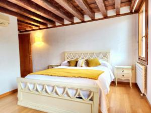 a bedroom with a large white bed with yellow sheets at Lo Squero apt in Venice