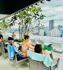 two women sitting in chairs on a patio overlooking the water at Axon Residence By TS in Kuala Lumpur