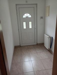 um quarto vazio com uma porta e um piso de azulejo em L&L em Saraievo