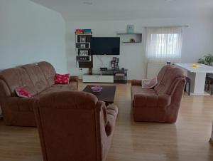 a living room with two chairs and a flat screen tv at L&L in Sarajevo