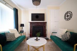 a living room with a green couch and a table at Dundrine Cottage in Maghera