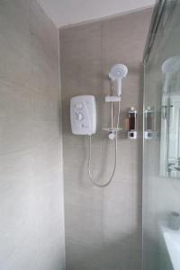 a shower with a shower head in a bathroom at Dundrine Cottage in Maghera