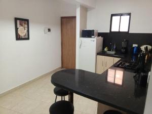 eine Küche mit einer schwarzen Arbeitsplatte und einem Kühlschrank in der Unterkunft Arriendo Ciudad Flamingo in El Marite