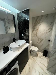 uma casa de banho com um lavatório e um WC em Paris Bleu em Puteaux