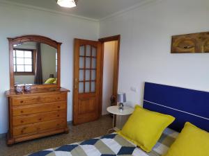 1 dormitorio con cama, tocador y espejo en Los atardeceres más bellos del Sauzal, en Sauzal