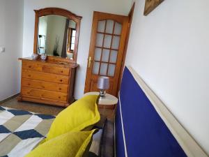 a bedroom with a bed and a mirror and a dresser at Los atardeceres más bellos del Sauzal in Sauzal