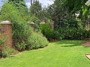 un giardino con recinzione e prato verde di Clarens Mountain Sage Cottage a Clarens Altre 23 foto