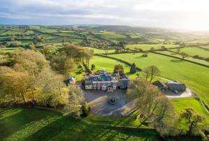 an aerial view of a large house in a field at Ludbrook Manor in Ivybridge
