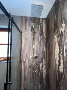 La salle de bains est pourvue d'une douche avec un pommeau de douche. dans l'établissement Nevis Croft Apartment 3, à Fort William