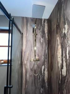 a shower with a shower head in a bathroom at Nevis Croft Apartment 3 in Fort William